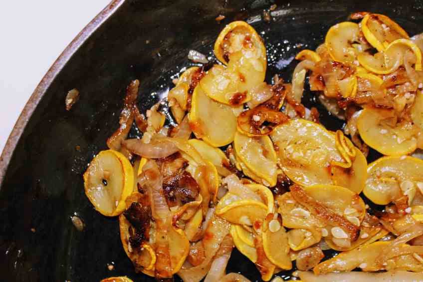 Keto Yellow Squash and Onions cooking in cast iron pan