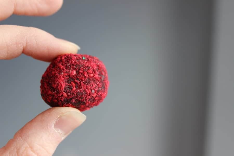Don't have a chocolate mold? No problem! Keto Chocolate Raspberry Truffles are super easy to make when you skip the mold and skip the coating. Roll in whatever topping you like! Here we use freeze-dried raspberry crumbles. Yum! #easytruffles #easyketotruffles #easyketocandy #easyketodessert #valentinesdaydessert #valentinesdessert #ketovalentine