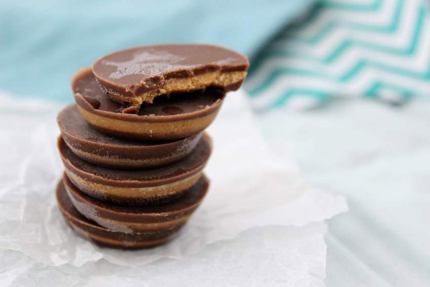 Stack of keto peanut butter cups on parchment paper