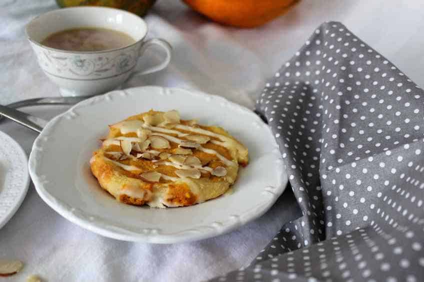 Keto Pumpkin spice Cream Cheese Danish on fancy white plate next to a cup of hot cocoa