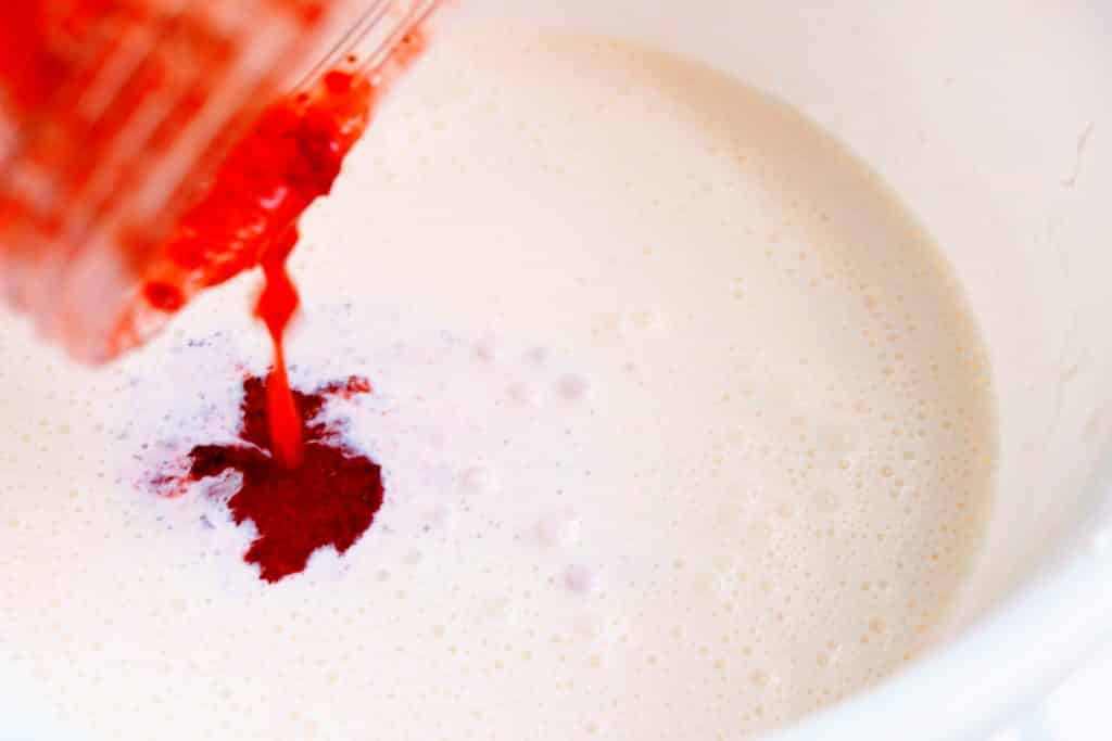 strawberries and cream ice cream - keto - pouring strawberries into cream mixture